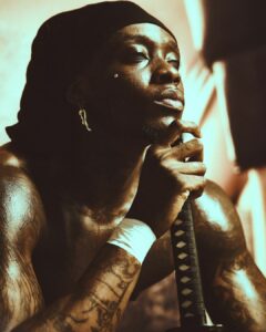 Himra, rappeur ivoirien, posant avec un katana, symbole de force et de stratégie musicale internationale.