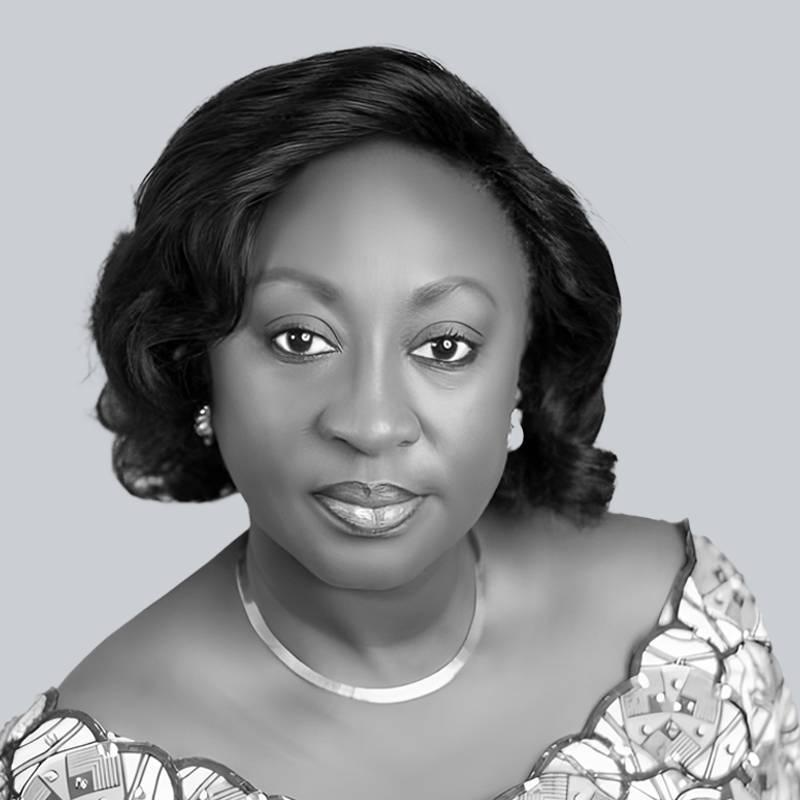 Portrait en noir et blanc d’une femme posant en style professionnel sur fond uni.